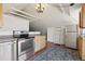 Charming kitchenette with white-painted, raftered ceiling, stainless steel appliances, and vintage-style range at 1345 N Franklin St, Denver, CO 80218