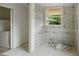 Bathroom in progress of renovation, featuring new waterproof wallboards and a window for natural light at 7313 S Boulder Rd, Boulder, CO 80303