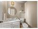 Half bath featuring white vanity, round mirror, a shelf, and neutral paint at 14822 E Penwood Pl # D, Aurora, CO 80015