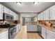 Well-lit kitchen featuring white cabinets, stainless steel appliances, and hardwood floors at 14822 E Penwood Pl # D, Aurora, CO 80015