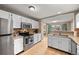 Functional kitchen featuring white cabinets, stainless steel appliances, and a view of the dining area at 14822 E Penwood Pl # D, Aurora, CO 80015