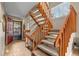 View of the wood staircase with carpet runner leading to the front door with a storm door at 14822 E Penwood Pl # D, Aurora, CO 80015