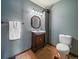 Cozy bathroom featuring a wooden vanity with an octagonal mirror, tile floors, and a toilet at 10852 Conifer Mountain Rd, Conifer, CO 80433