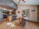 Dining area with a view of the kitchen and the surrounding trees through a large window at 10852 Conifer Mountain Rd, Conifer, CO 80433