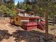 Exterior side view of the two-story home, showcasing the deck and natural landscaping at 10852 Conifer Mountain Rd, Conifer, CO 80433