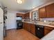 Traditional kitchen with wood cabinets, tile flooring, black appliances and white door to adjacent space at 10852 Conifer Mountain Rd, Conifer, CO 80433