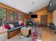 Living room with wood paneling, wood burning stove, and cozy seating area at 10852 Conifer Mountain Rd, Conifer, CO 80433