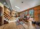 Bright living room featuring wood floors, a skylight, and views of the surrounding forest at 10852 Conifer Mountain Rd, Conifer, CO 80433