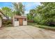 Backyard concrete patio with a wooden shed, surrounded by greenery and a wooden fence at 1828 Stratford Ln, Longmont, CO 80503