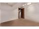 Empty room featuring neutral carpet, white walls and trim, and a wood door at 1828 Stratford Ln, Longmont, CO 80503