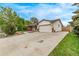 Spacious home exterior featuring an attached garage and large driveway at 1828 Stratford Ln, Longmont, CO 80503