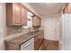 Charming kitchen with wood cabinets, stainless sink, tile backsplash, and wood-look flooring at 1828 Stratford Ln, Longmont, CO 80503