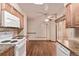 Bright kitchen leading into eating area with wood cabinets, tile backsplash, and wood-look floors at 1828 Stratford Ln, Longmont, CO 80503