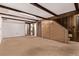 Spacious living room featuring wood paneling, carpet flooring, and exposed ceiling beams at 1828 Stratford Ln, Longmont, CO 80503