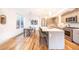 A modern kitchen with stainless steel appliances, an island with seating, and a dining area with natural light at 822 Fairfax St, Denver, CO 80220