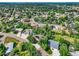 Expansive aerial view of a neighborhood with mature trees and lush landscaping with mountain views at 8165 W Stene Dr, Littleton, CO 80128