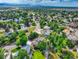 Panoramic aerial view of a neighborhood with mature trees and lush landscaping with a lake and mountains at 8165 W Stene Dr, Littleton, CO 80128