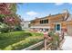 View of backyard with well-manicured lawn, mature trees, and a charming wooden fence at 8165 W Stene Dr, Littleton, CO 80128