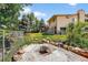 Spacious backyard featuring mature trees and a charming fire pit area for outdoor enjoyment at 8165 W Stene Dr, Littleton, CO 80128