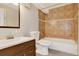 Bathroom featuring a vanity, toilet, tub with showerhead, and brown tile at 8165 W Stene Dr, Littleton, CO 80128