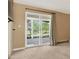 Bedroom with neutral carpet and walls, and large slider opening to a patio with views of mature trees at 8165 W Stene Dr, Littleton, CO 80128