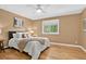Cozy bedroom featuring hardwood floors, a plush bed, and a large window with a peaceful view at 8165 W Stene Dr, Littleton, CO 80128