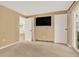 Carpeted bedroom with TV, closet, door to another room, and glass door to an outdoor deck at 8165 W Stene Dr, Littleton, CO 80128