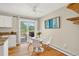 Bright dining area with hardwood floors, a modern round table, and sliding glass doors to the deck at 8165 W Stene Dr, Littleton, CO 80128