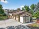 Inviting home featuring a large driveway, three-car garage, mature trees, and convenient storage shed at 8165 W Stene Dr, Littleton, CO 80128