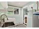 Well-lit laundry room features modern washer and dryer units, sink and patterned tile flooring at 8165 W Stene Dr, Littleton, CO 80128