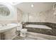 Elegant bathroom featuring marble walls, a luxurious soaking tub, and designer fixtures at 10729 Kipling Way, Broomfield, CO 80021