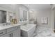 Elegant bathroom with a soaking tub, double vanity, and marble floors at 11633 Norfolk St, Commerce City, CO 80022