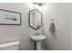 Powder room with pedestal sink, hexagon mirror, and modern fixtures at 11633 Norfolk St, Commerce City, CO 80022