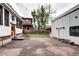 Backyard featuring a large stone patio, detached garage, and green lawn at 925 N Emerson St, Denver, CO 80218