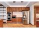 View of kitchen features stainless steel appliances, including double oven, and spacious wood cabinets at 925 N Emerson St, Denver, CO 80218