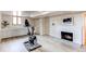 Finished basement with fireplace, storage cabinets, and a modern exercise bike at 2838 Forest St, Denver, CO 80207