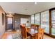 Dining area featuring wood table, and a view into the front yard through the large windows at 2838 Forest St, Denver, CO 80207