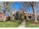 Charming brick home with a well-manicured lawn, garden and covered front porch at 2838 Forest St, Denver, CO 80207