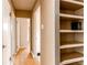 Hallway featuring beautiful hardwood floors, convenient storage shelves, and access to multiple rooms at 2838 Forest St, Denver, CO 80207