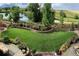 Expansive backyard featuring manicured lawn, flower beds, and scenic water view, perfect for outdoor relaxation and entertaining at 12371 Red Fox Way, Broomfield, CO 80021