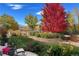 Picturesque backyard with mature trees and lush landscaping, offering stunning views of the adjacent pond and community at 12371 Red Fox Way, Broomfield, CO 80021