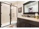 Bathroom featuring a glass-enclosed shower, dark vanity, and decorative mirror adding modern style at 12371 Red Fox Way, Broomfield, CO 80021