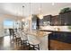 Modern kitchen with dark cabinets, granite countertops, stainless steel appliances, and a central island with bar seating at 12371 Red Fox Way, Broomfield, CO 80021