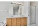 Bathroom with a double sink vanity featuring wooden cabinets, a large mirror, and a glass door shower at 2062 S Xenia Way, Denver, CO 80231