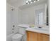 Bathroom with a toilet, bathtub, sink, and vanity with wood cabinets, and a large mirror at 2062 S Xenia Way, Denver, CO 80231