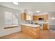 Bright kitchen features wood cabinets, a breakfast bar, white appliances, and a large window at 2062 S Xenia Way, Denver, CO 80231