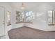 Bright living room with ample natural light, neutral carpet, chandelier and large windows at 2062 S Xenia Way, Denver, CO 80231