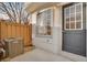 Outdoor patio with a gray door, air conditioning unit, and wooden fence at 2062 S Xenia Way, Denver, CO 80231