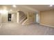 Spacious finished basement with neutral carpet, large open area, and stairs leading to the upper level at 10652 W Florida Ave # D, Lakewood, CO 80232