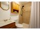 Well-lit bathroom with a shower, tiled walls, and ample storage in the upper cabinet at 10652 W Florida Ave # D, Lakewood, CO 80232